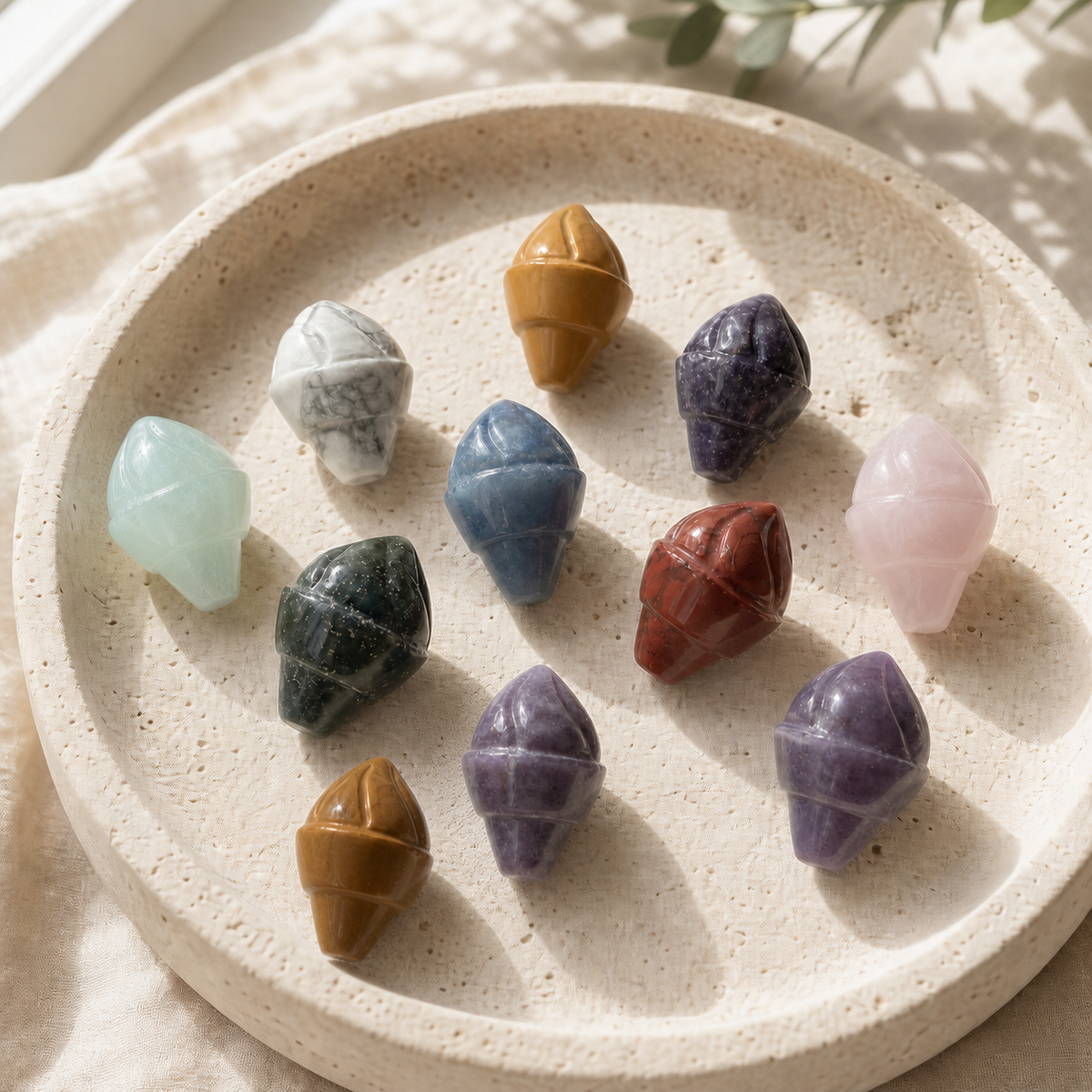 Assorted polished crystal ice-cream carvings displayed on a cream travertine plate