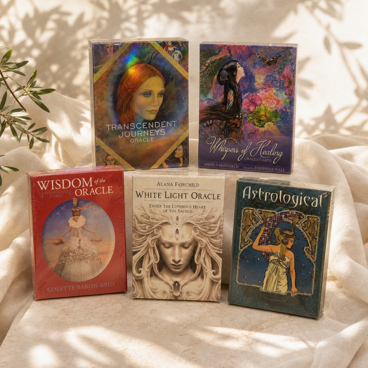 Five sealed Oracle card decks displayed in warm natural light