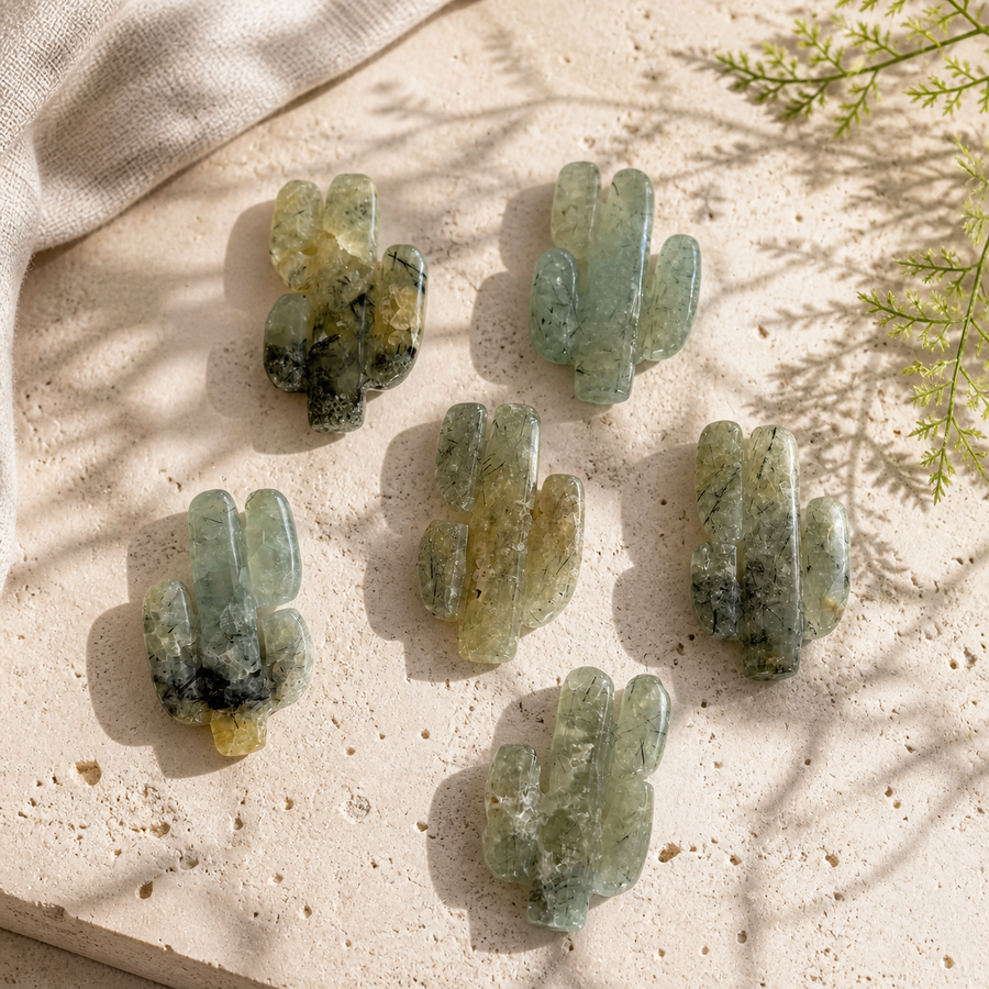 Group of six polished Prehnite cactus crystal carvings in warm natural light