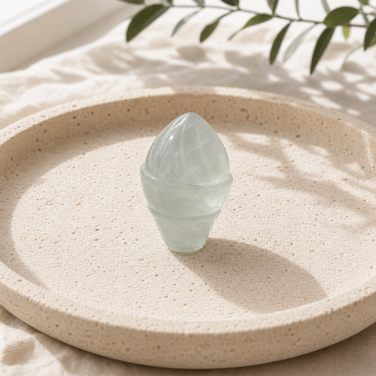 Green Fluorite crystal ice-cream carving standing on a cream travertine plate