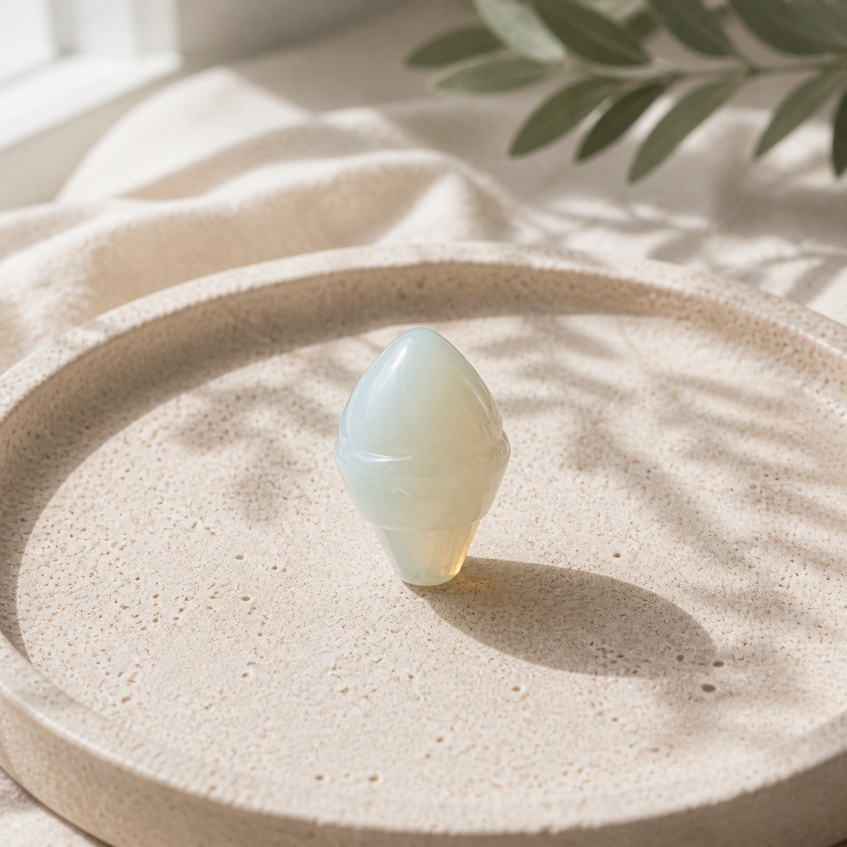 Opalite crystal ice-cream carving standing on a cream travertine plate
