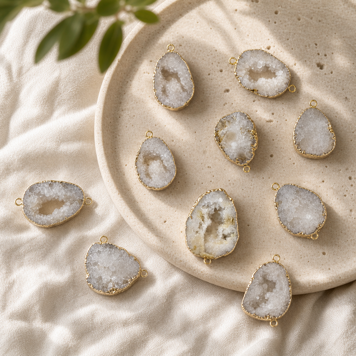 White Druzy Agate pendants and two-hole connectors arranged on a round stone plate